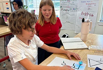 Two students work together at a desk