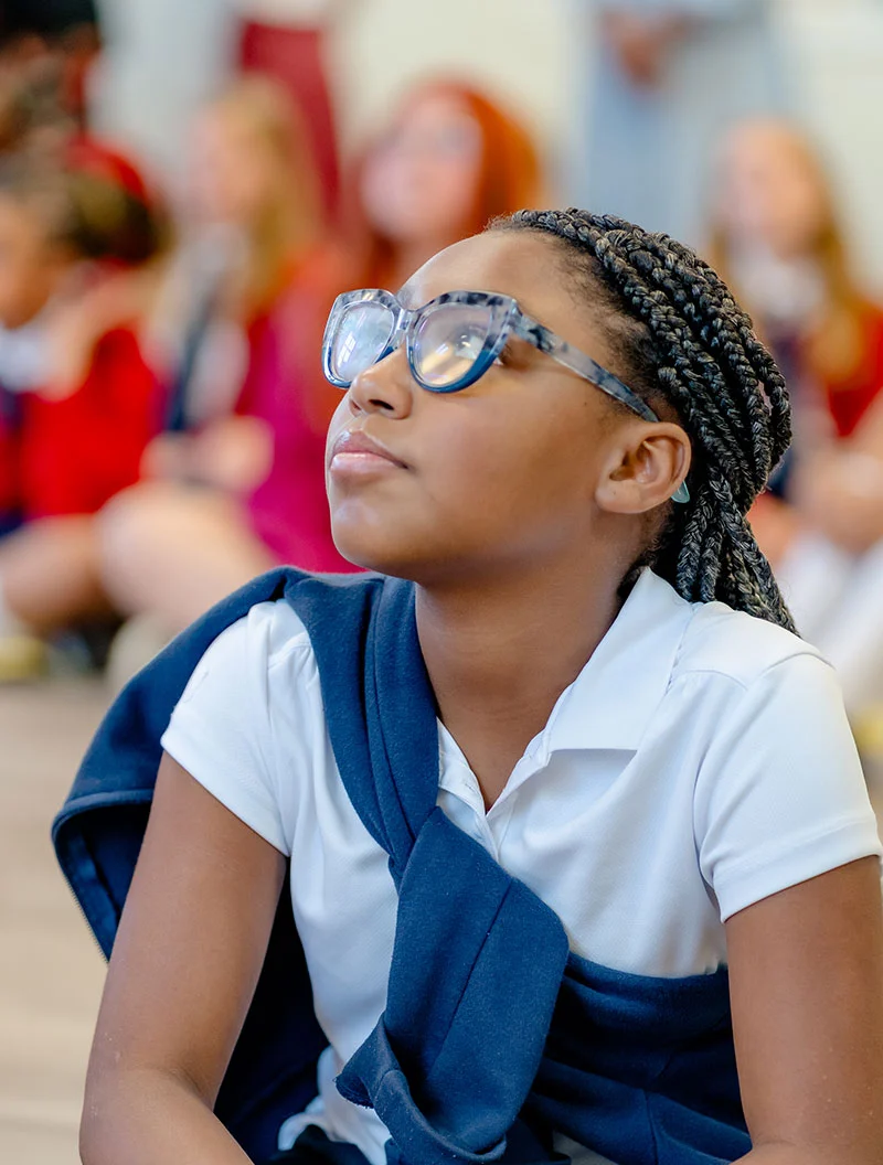 braided-girl-with-glasses-looking-up young girl looking up with blue glasses and braids