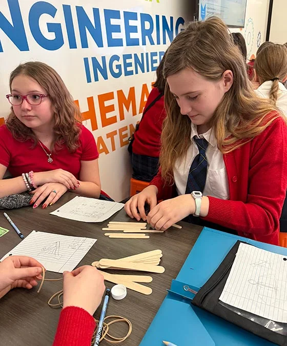 two girls in red and blue school uniforms walking into class