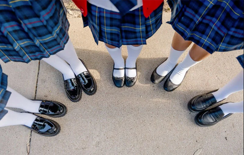View of girls uniforms and shoes facing down