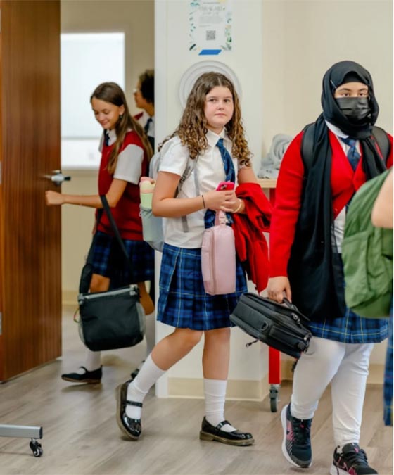 multiple girls walking into a classroom