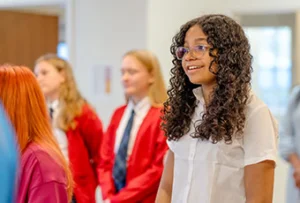 student-white-shirt-smiling Girls stand and smile together.
